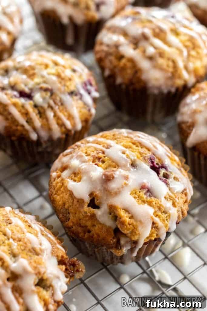 raspberry white chocolate muffins on wire rack being glazed