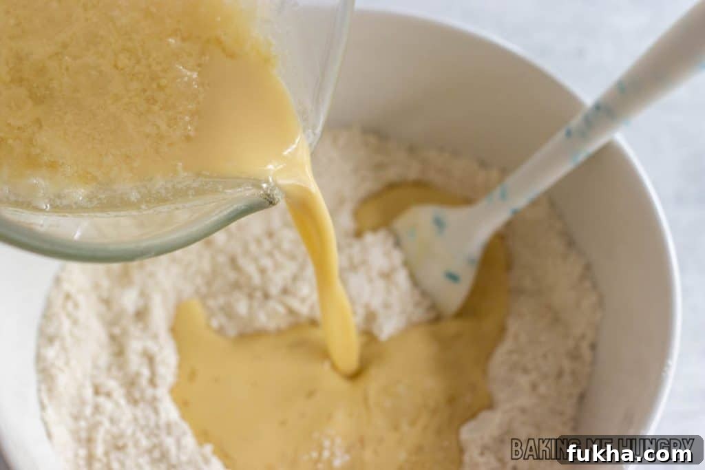 wet ingredients being poured into bowl of dry ingredients