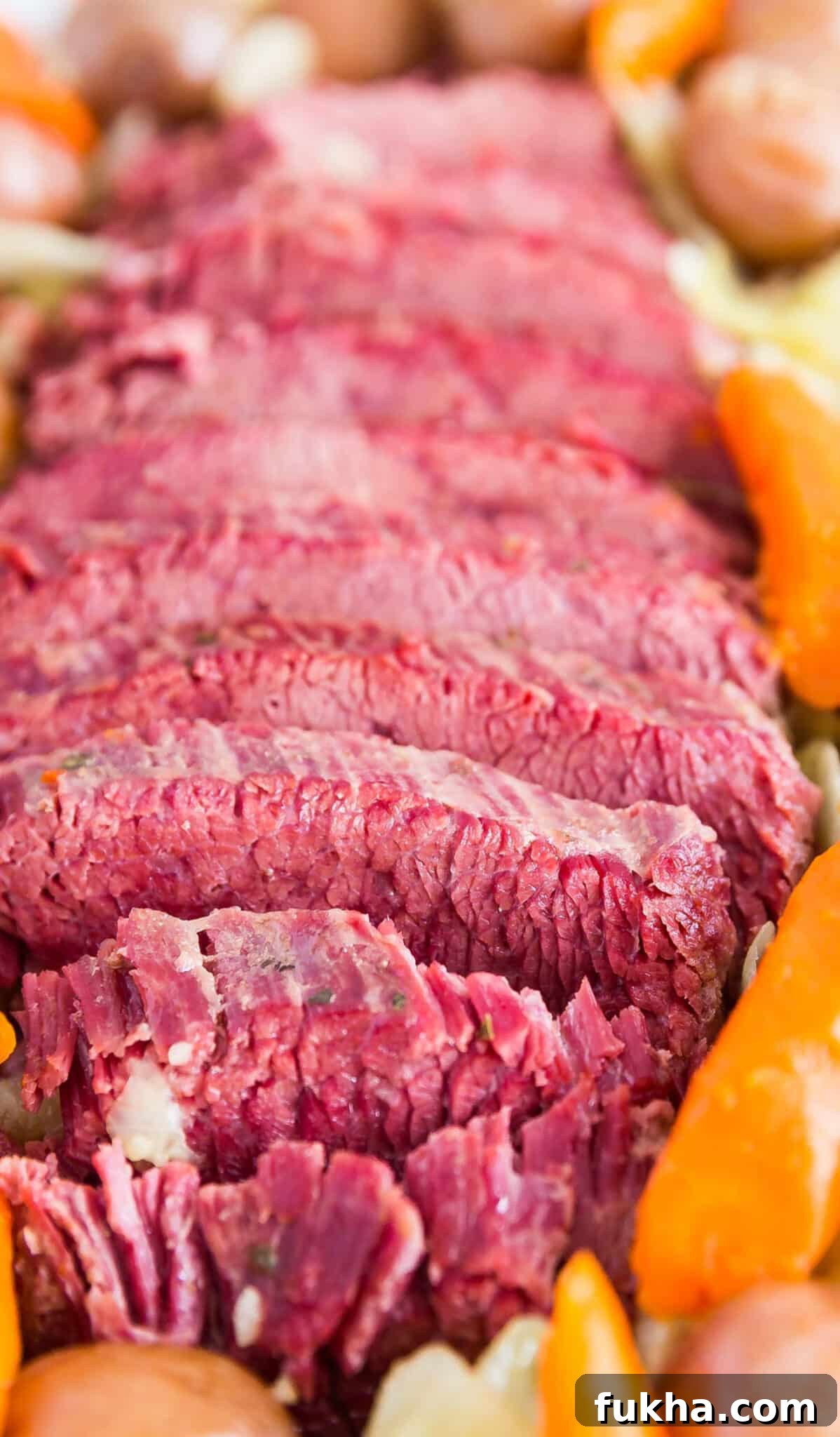 A close up image of sliced corned beef and veggies.