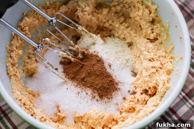 Pumpkin cream cheese mixture and sweetener in a bowl for no bake pumpkin cheesecake balls