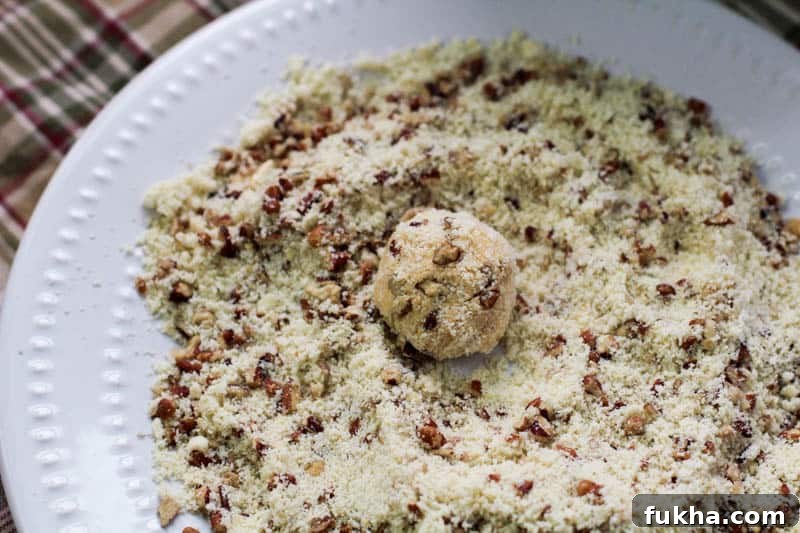 Ball of pumpkin cheesecake rolled in almond flour and crushed pecans