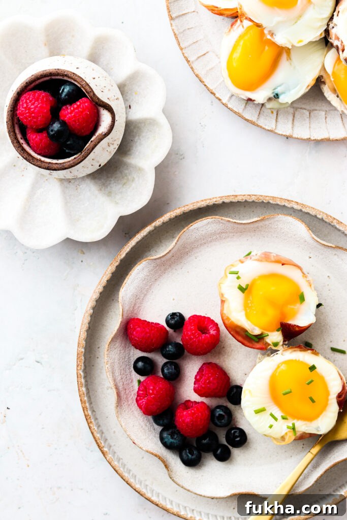 Prosciutto Egg Cups 1 Prosciutto Egg Cups on a plate with fruit