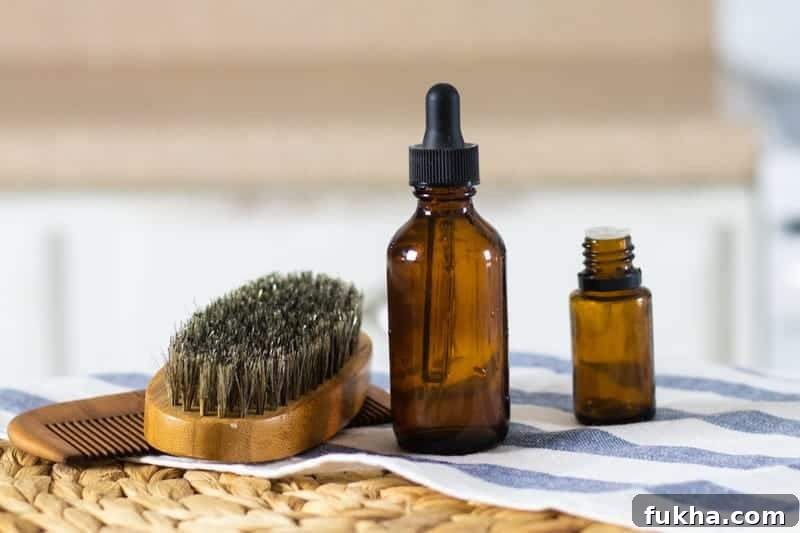 Beard shampoo on table with essential oil bottle, beard brush, and bread comb next to it.