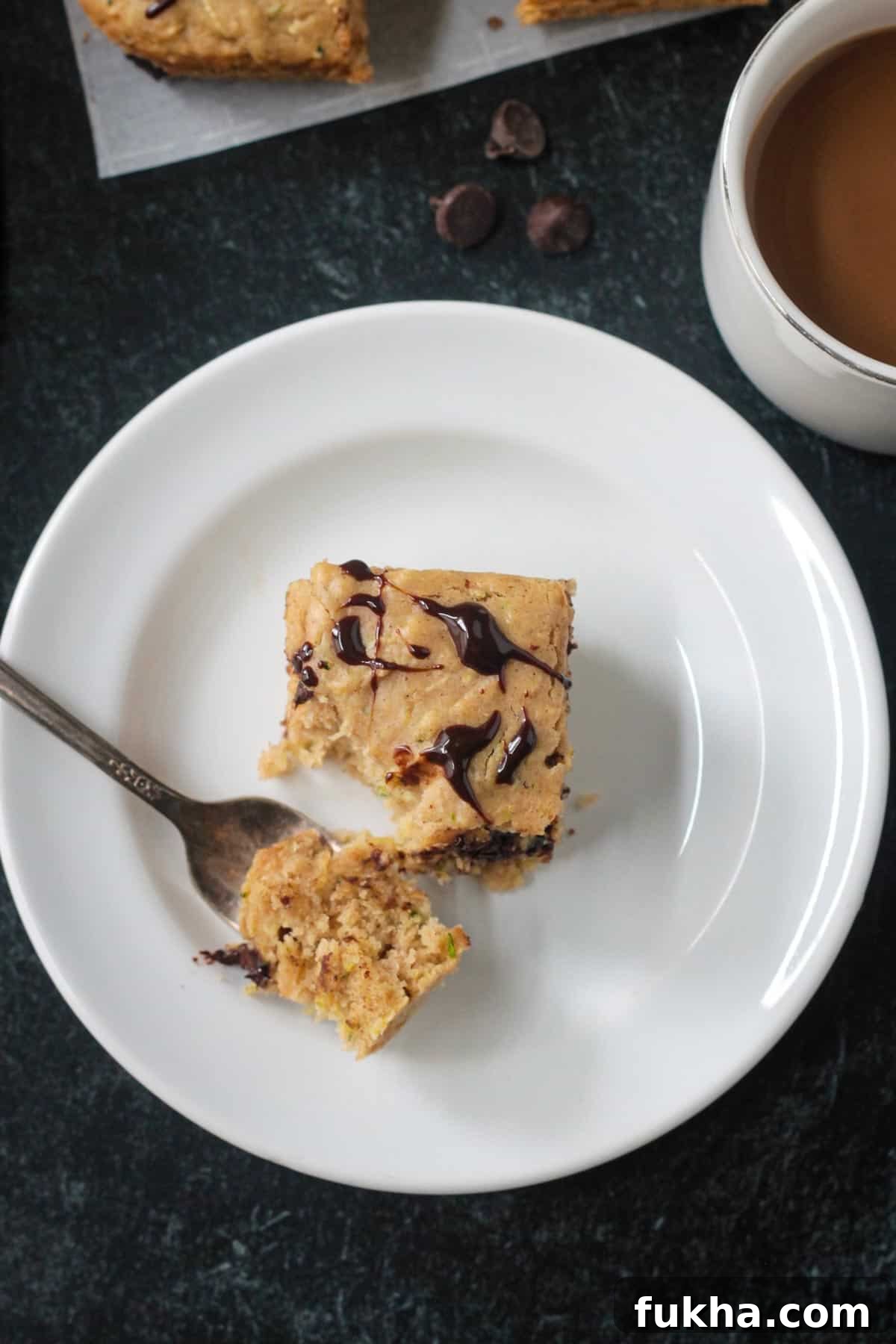 Bite of cake on a fork on a plate.