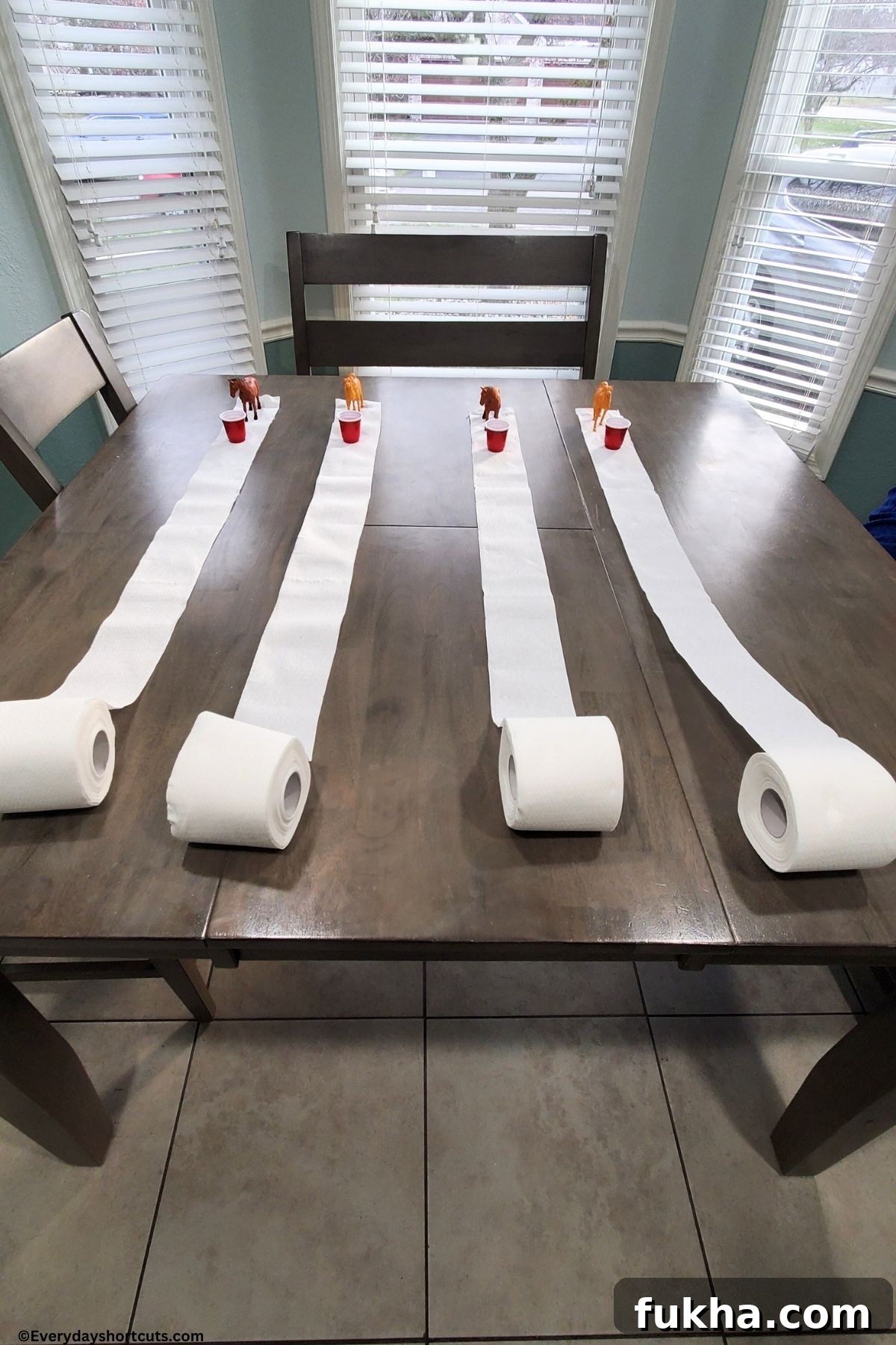 Toilet Paper derby with plastic mini horses shot glasses with water and toilet paper