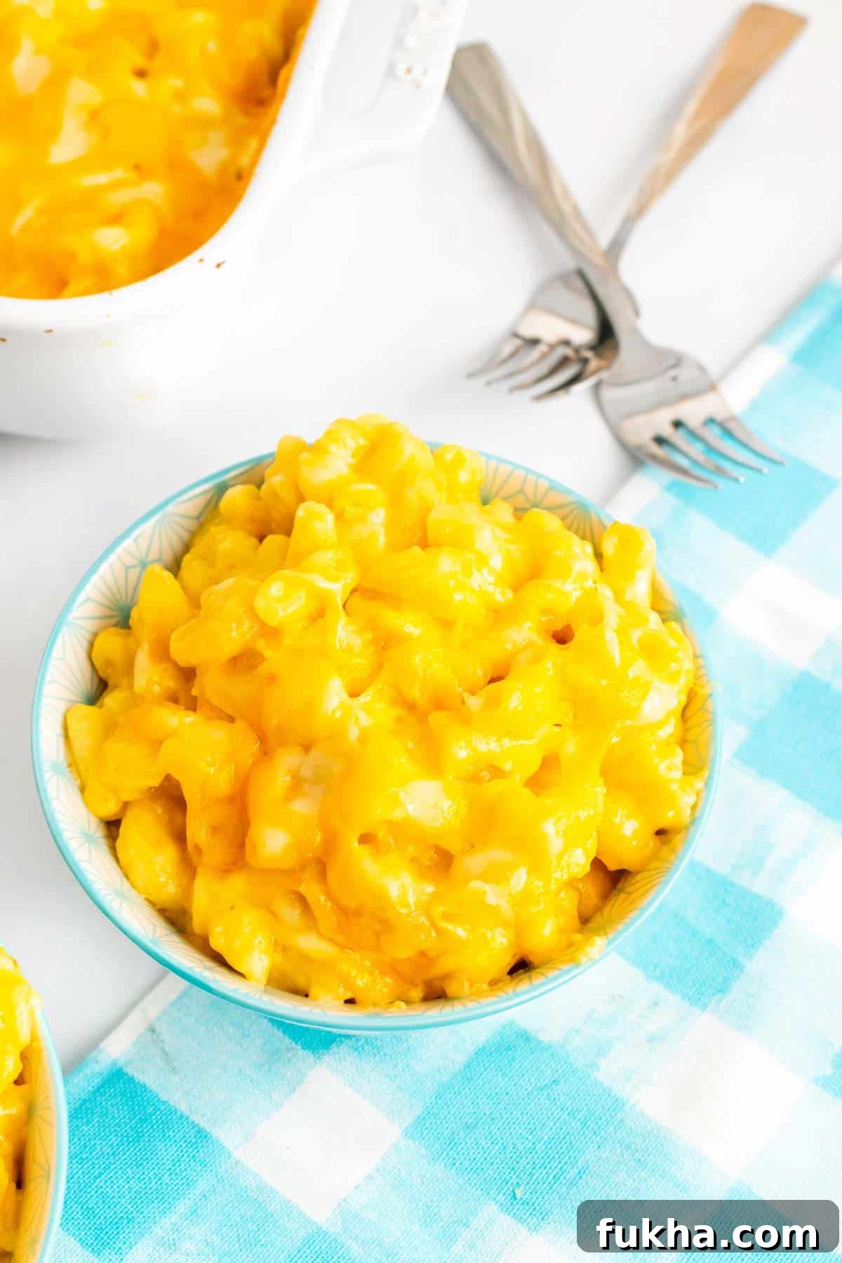 One-Pot No-Boil Mac and Cheese 8 Extra creamy, cheesy macaroni and cheese in a small bowl next to a baking dish of mac and cheese.