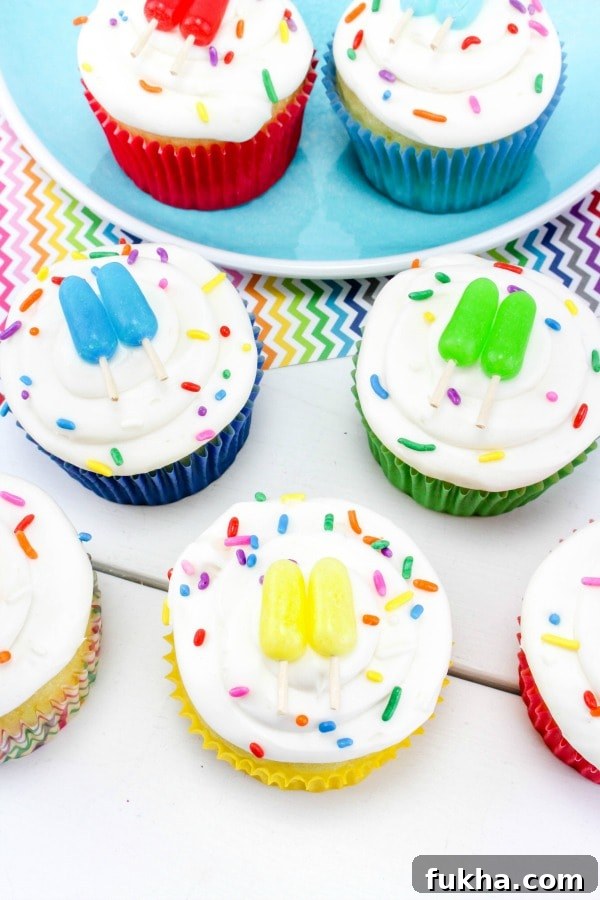 cupcakes on table that are decorated to look like popsicle sticks