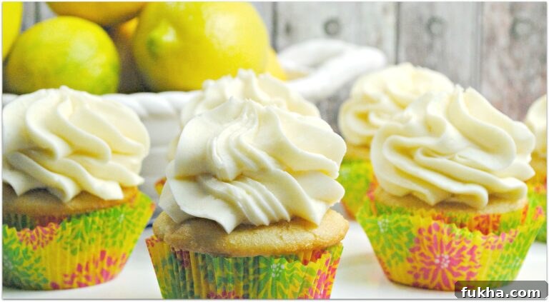 lemon flavored cupcakes on table with bowl of lemons in background 