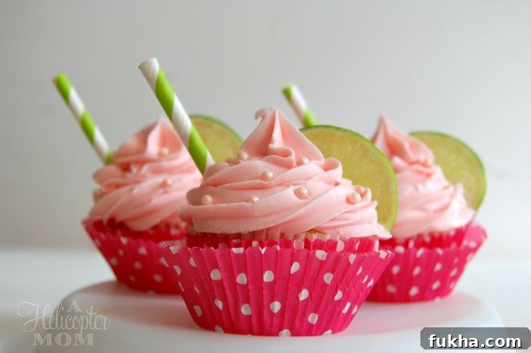 strawberry margarita cupcakes with straw sticking out on sides on a cupcake stand 