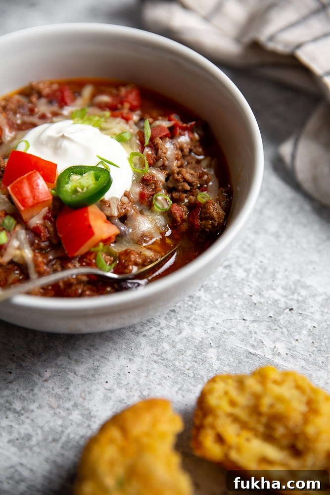 Slow-Cooker Beef Chili Recipe with Rich Smoky Flavor 2 Close-up side view of a bowl of chili with a spoon.