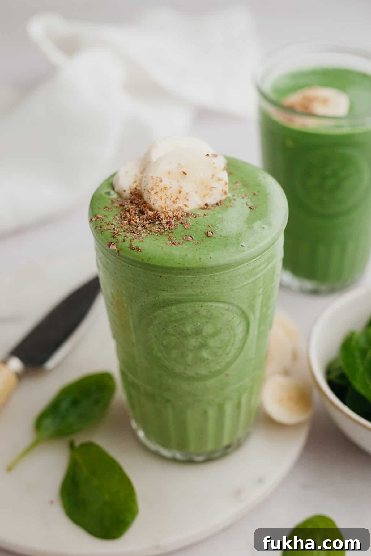 Creamy banana spinach smoothie in a tall glass