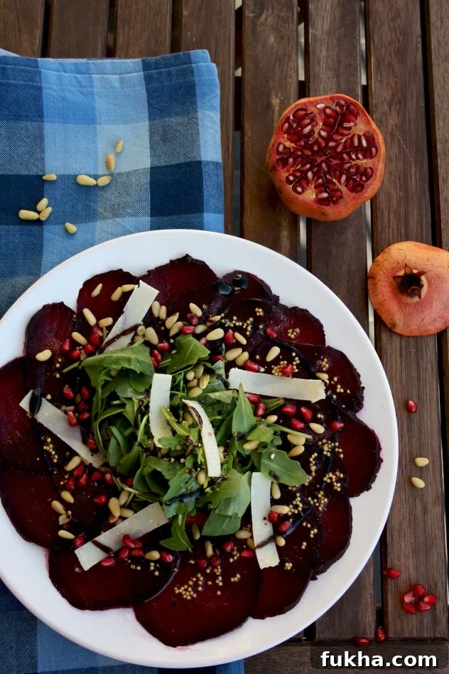 A beautiful, effortless, healthy and flavorful beetroot carpaccio with orange mustard vinaigrette and pomegranate seeds, served with parmesan and arugula.