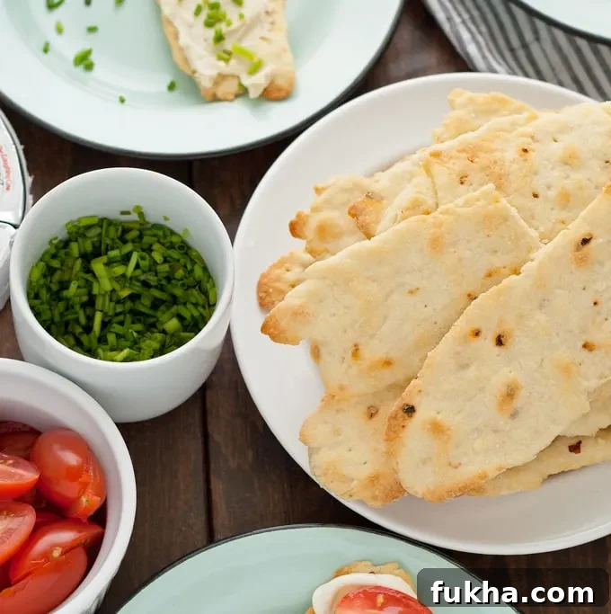 Red pepper flatbread crackers with creamy cheese and chopped vegetables