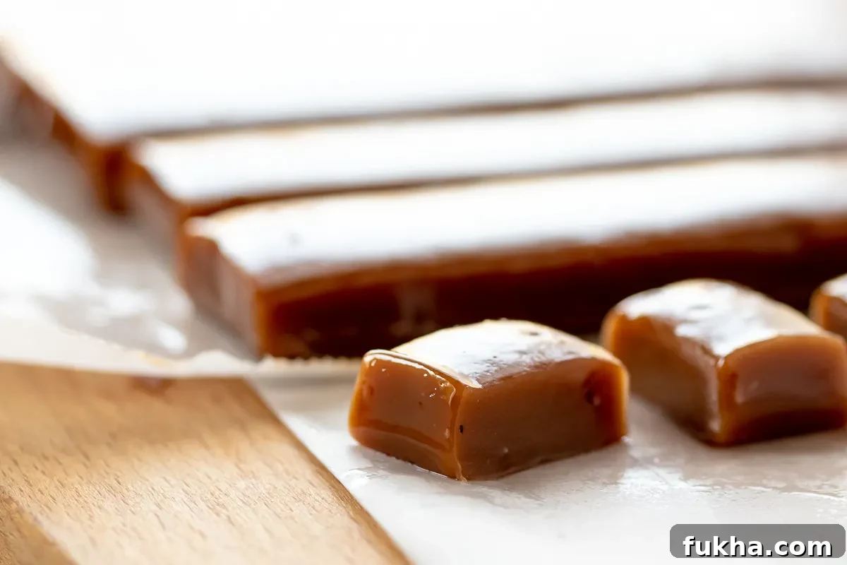 How to Make Chai Tea Caramels at Home 3 up close shot of homemade caramels to show texture. caramels are on a wooden cutting board and white parchment paper