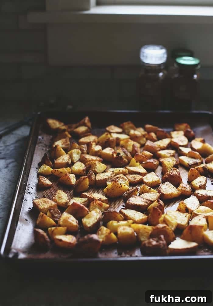 Crispy Roasted Potatoes: Oven and Air Fryer Methods 3 crispy roasted potatoes on a sheet pan with a silicone mat