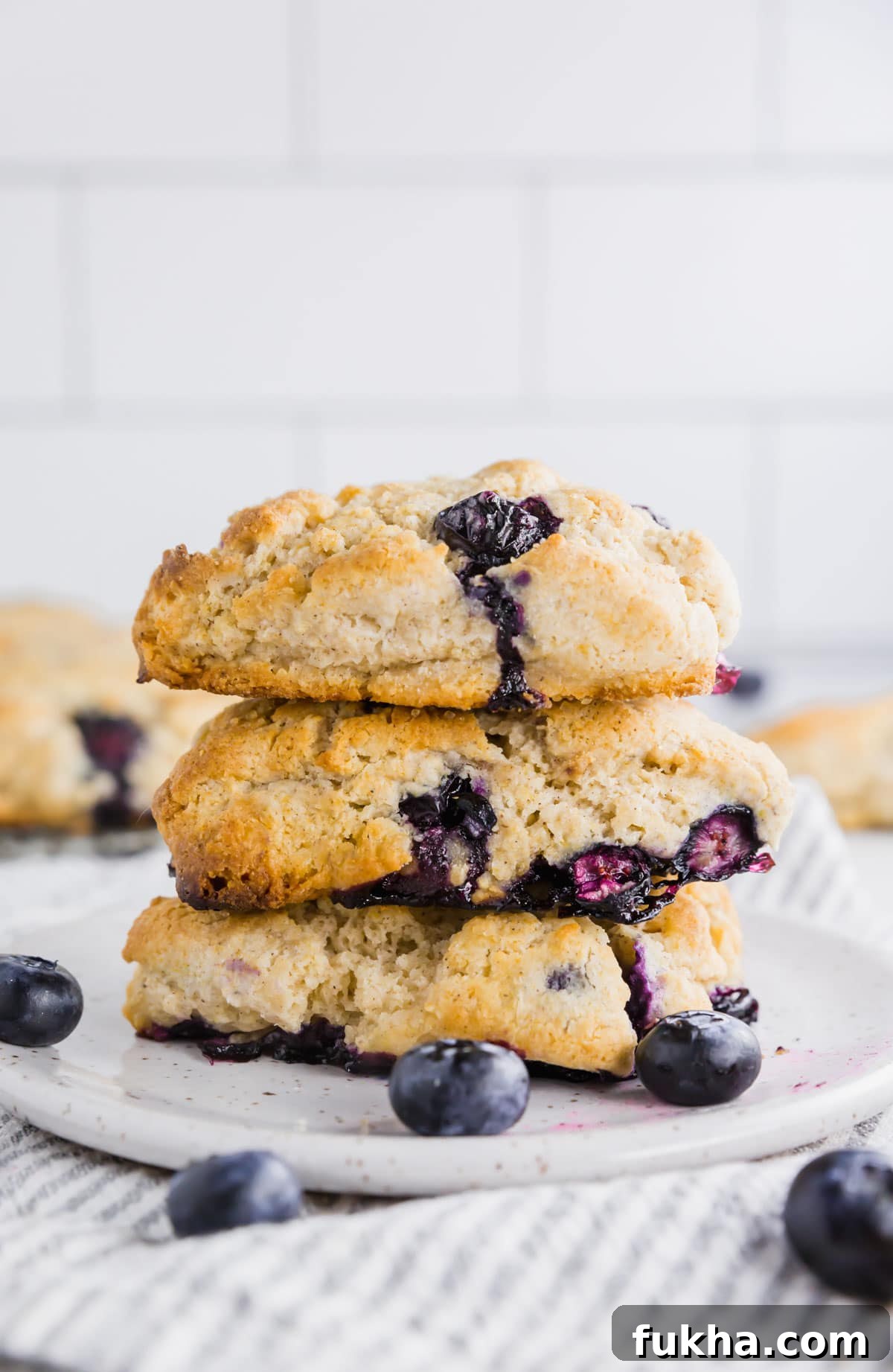 A stack of three gluten-free blueberry scones on a small plate.