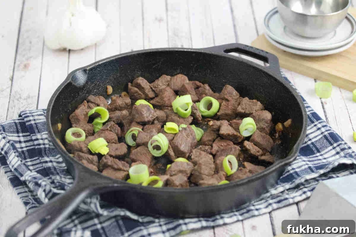 Teriyaki steak bites in a cast iron pan.