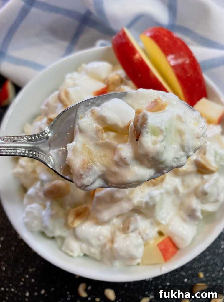 A spoonful of taffy apple salad with sliced apples on the side.