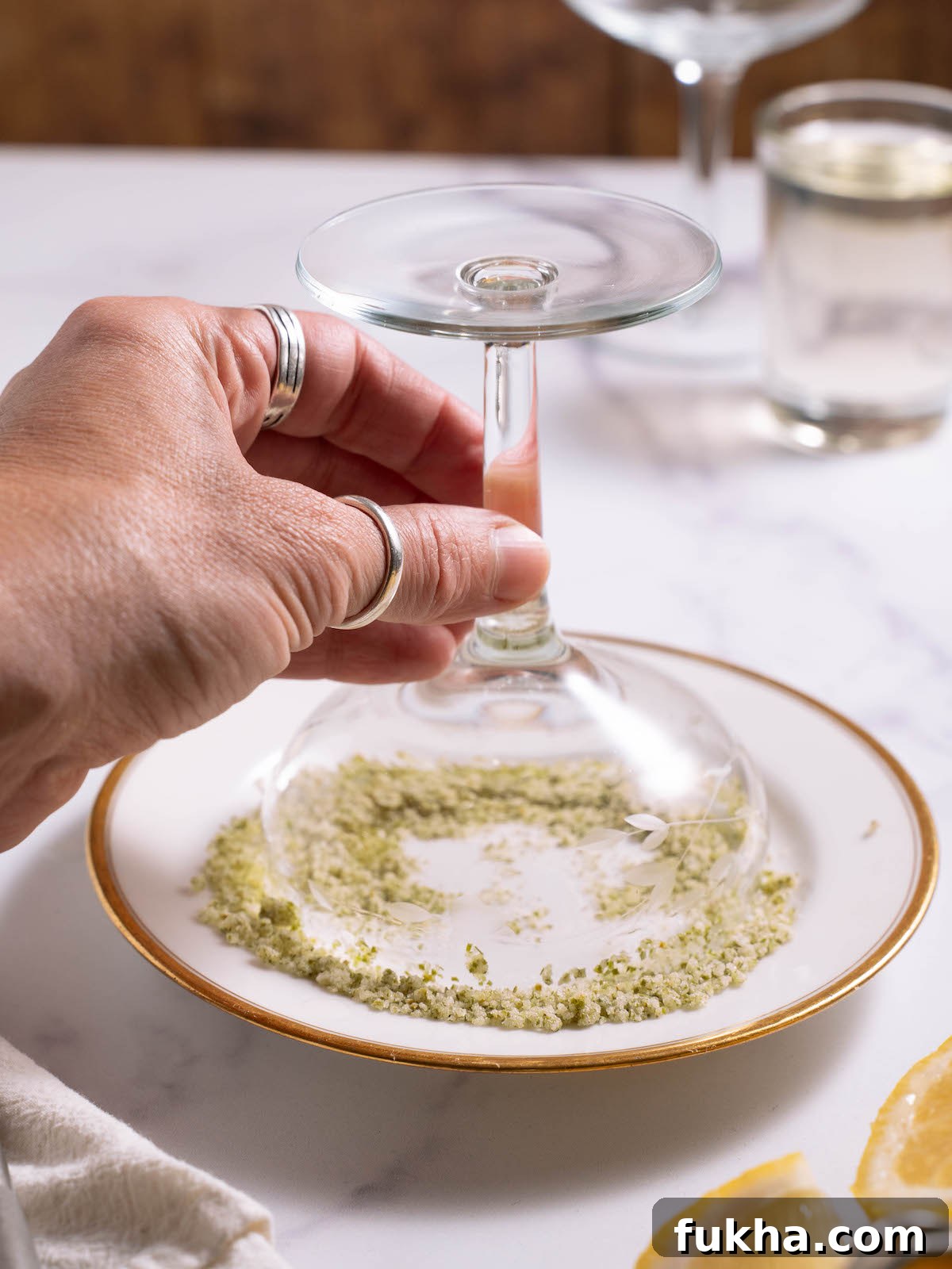 Lining the rim of a coupe glass with fir tip sugar