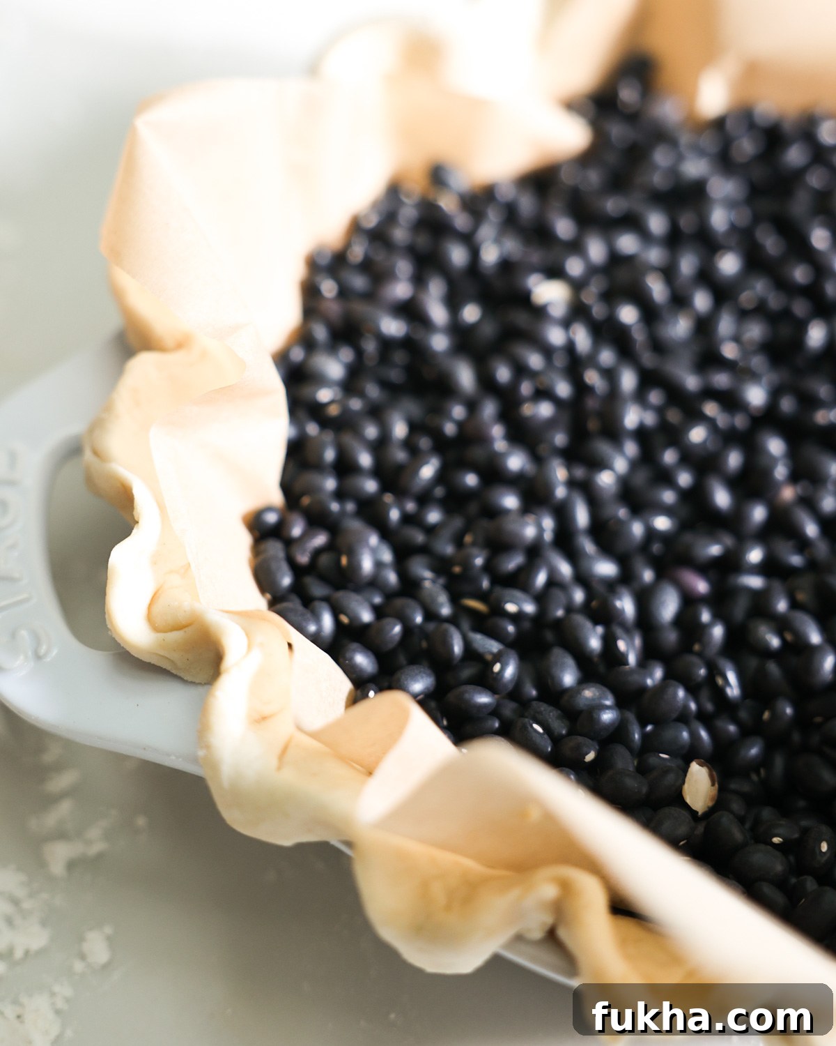 beans and parchment paper in a vegan pie crust to blind bake