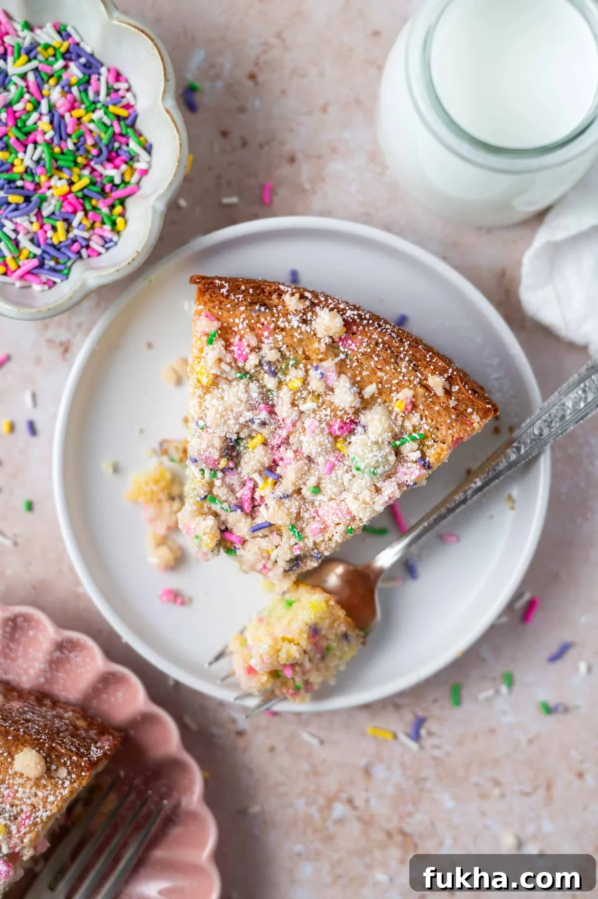 Single Layer Cake Recipes Without Frosting 3 slice of sprinkle cake on a plate with a bite on a fork and a glass of milk