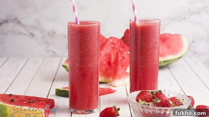 Two glasses filled with strawberry watermelon smoothie.
