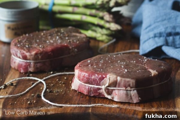 Filet mignon portion tied with string with asparagus.