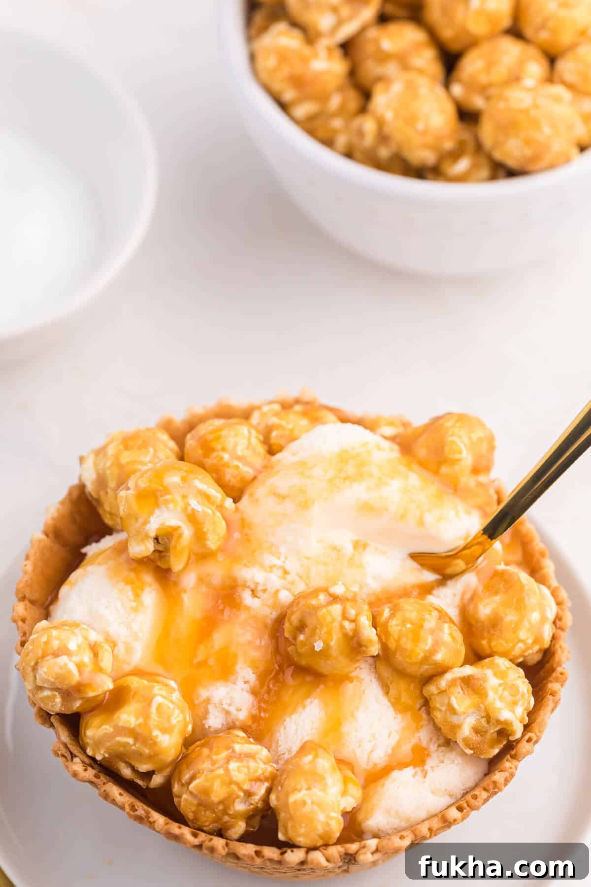 Caramel Crunch Ice Cream Sundae Recipe 6 Caramel crunch ice cream sundae on a plate with a small gold spoon in it.