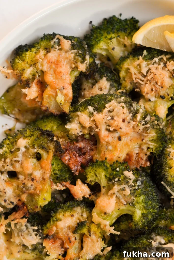 Crispy Smashed Broccoli with Parmesan 10 smashed broccoli parmesan in a serving bowl with lemon wedges.