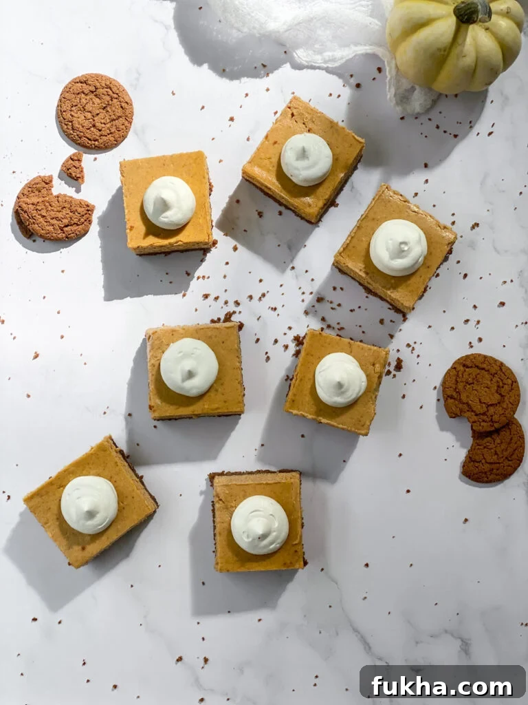 squares of cheesecake bars scattered around with gingersnap cookies
