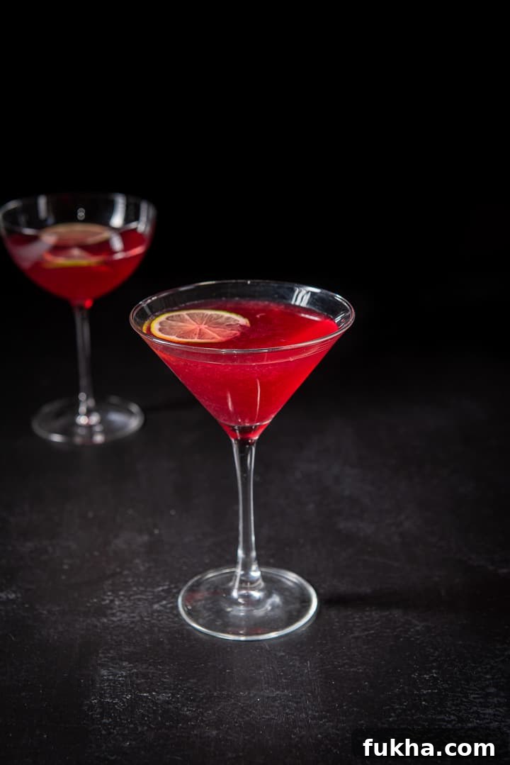 Pomegranate Cosmo Cocktail Recipe 6 Pomegranate cocktail in the classic martini glass in front of the bowl glass filled with the red cocktail