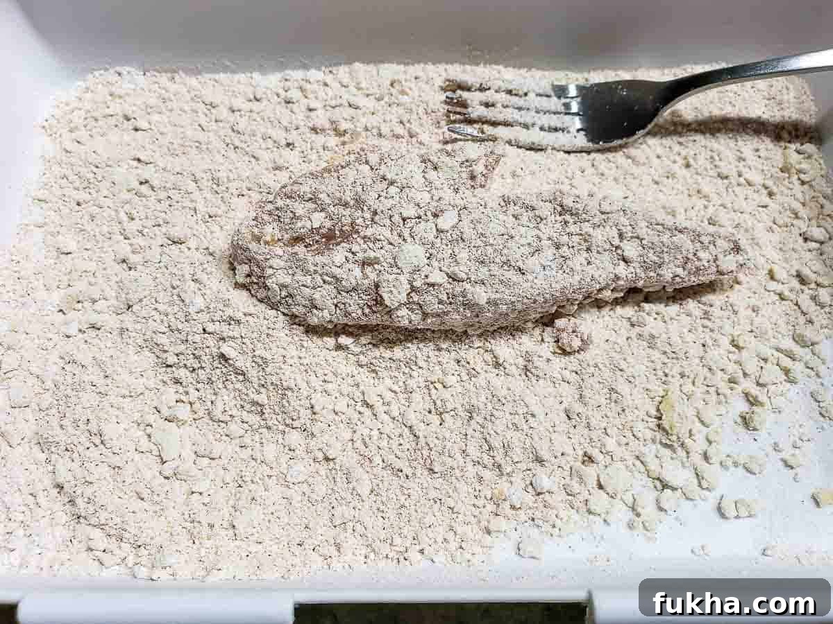 a chicken finger coated in flour and seasonings