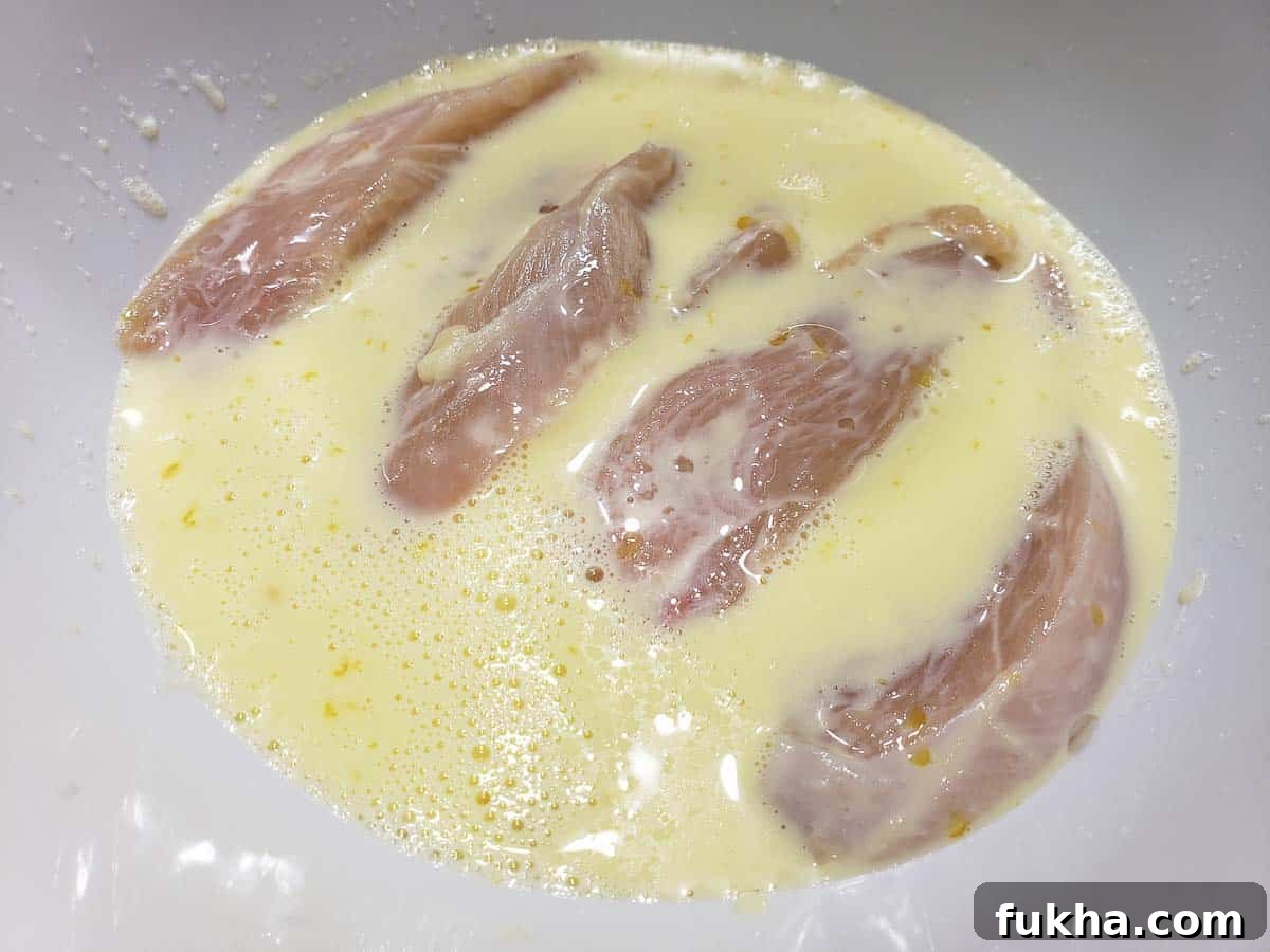 chicken strips soaking in homemade buttermilk and egg mixture