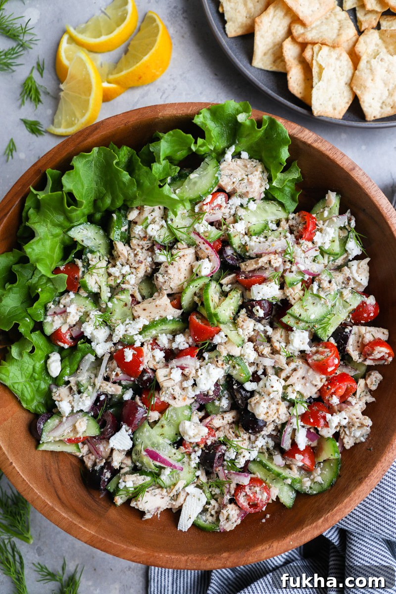 Mediterranean Tuna Salad with Feta and Lemon Vinaigrette 7 A large serving bowl filled with Mediterranean tuna salad served alongside a plate of crackers and fresh lemon wedges