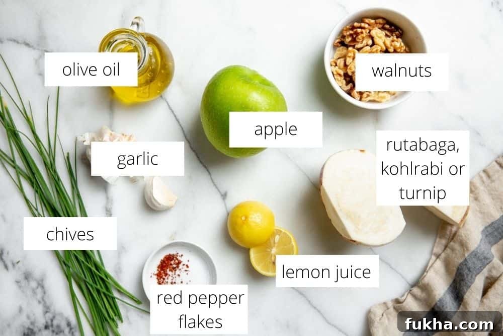 The ingredients for the apple slaw recipe on a marble surface with labels.