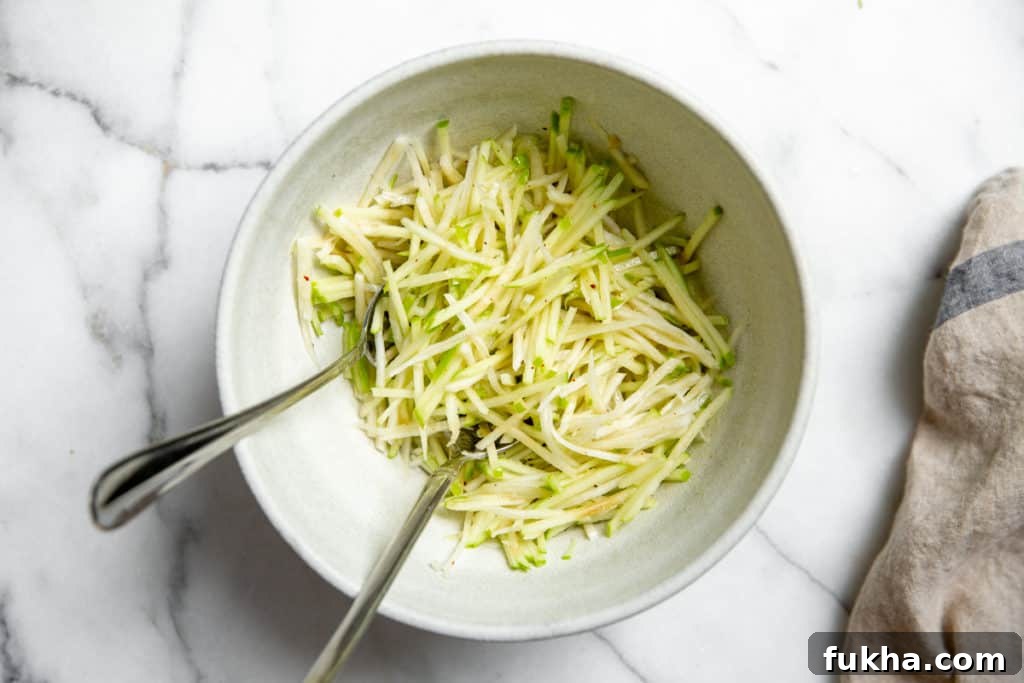 Shredded apple and rutabaga in a bowl tossed with the no-mayo dressing.