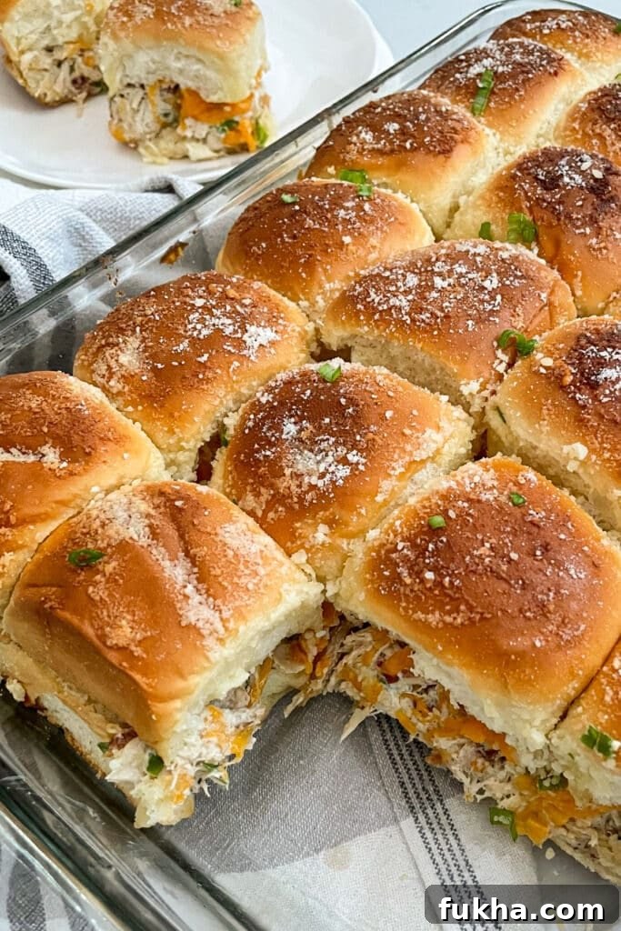 Crack chicken sliders in a baking pan with sliders on a serving plate