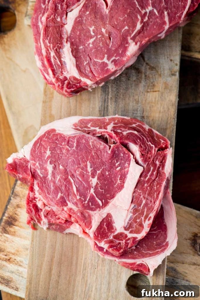 raw cuts of new york strip showing fat marbling across the surface
