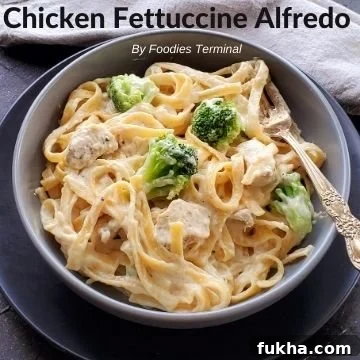 chicken fettuccine alfredo with broccoli in a grey bowl with a fork