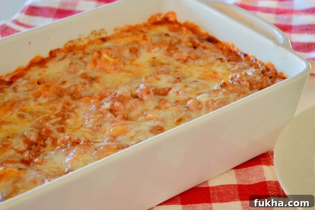 Cheesy Baked Tortellini Casserole with Meat Sauce 4 Pasta bake in a white dish on a checkered napkin.
