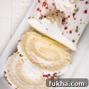 Sliced white roll cake topped with crushed red and green M&Ms.