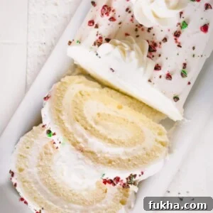 Sliced white roll cake topped with crushed red and green M&Ms.