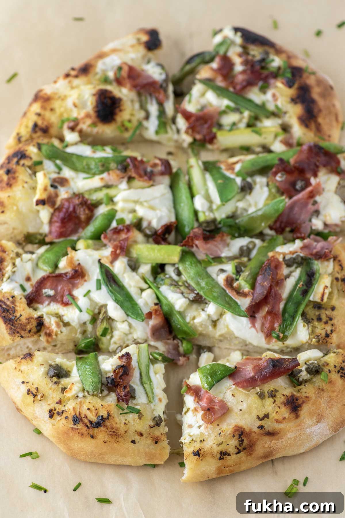 spring pizza sliced on parchment paper