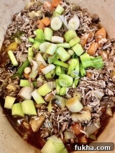 adding spring onions to dirty rice