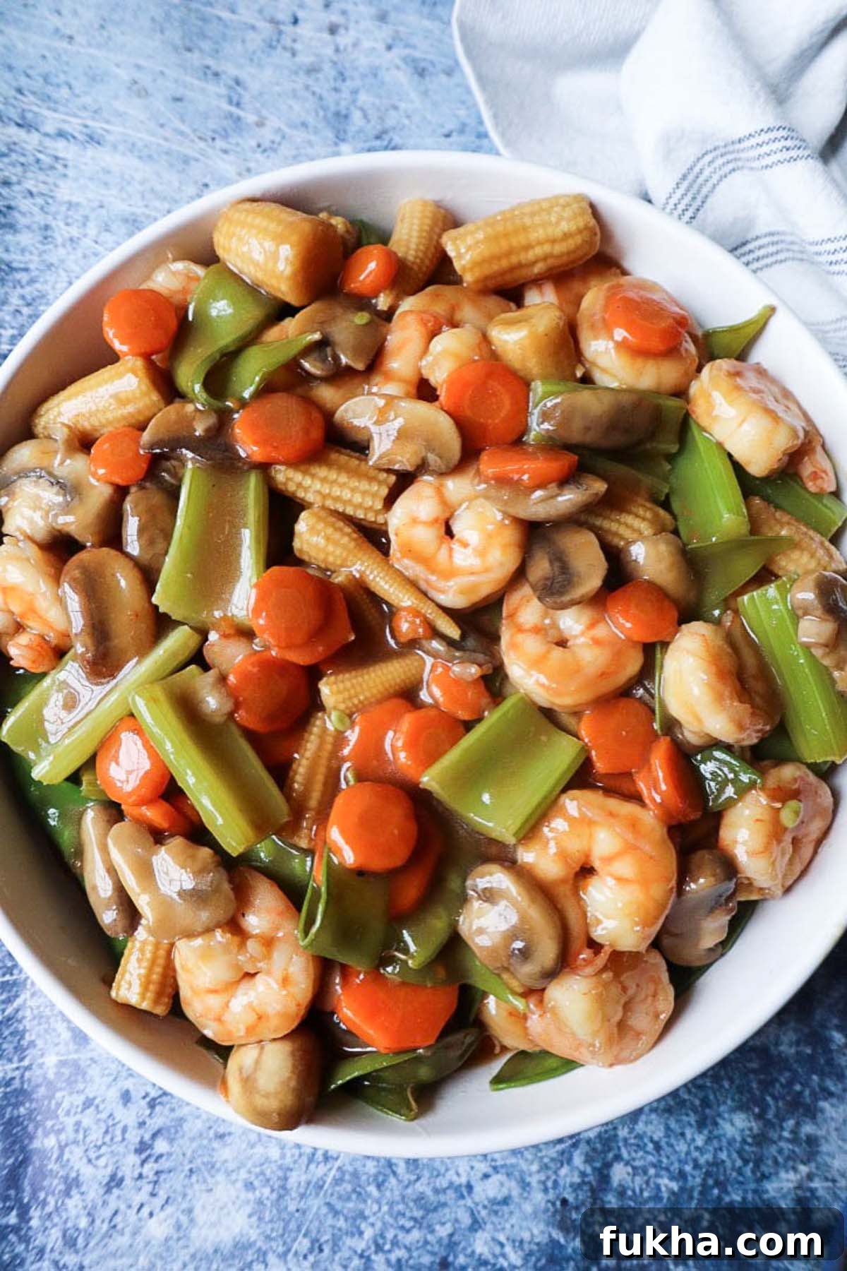 white bowl with shrimp chop suey with blue background