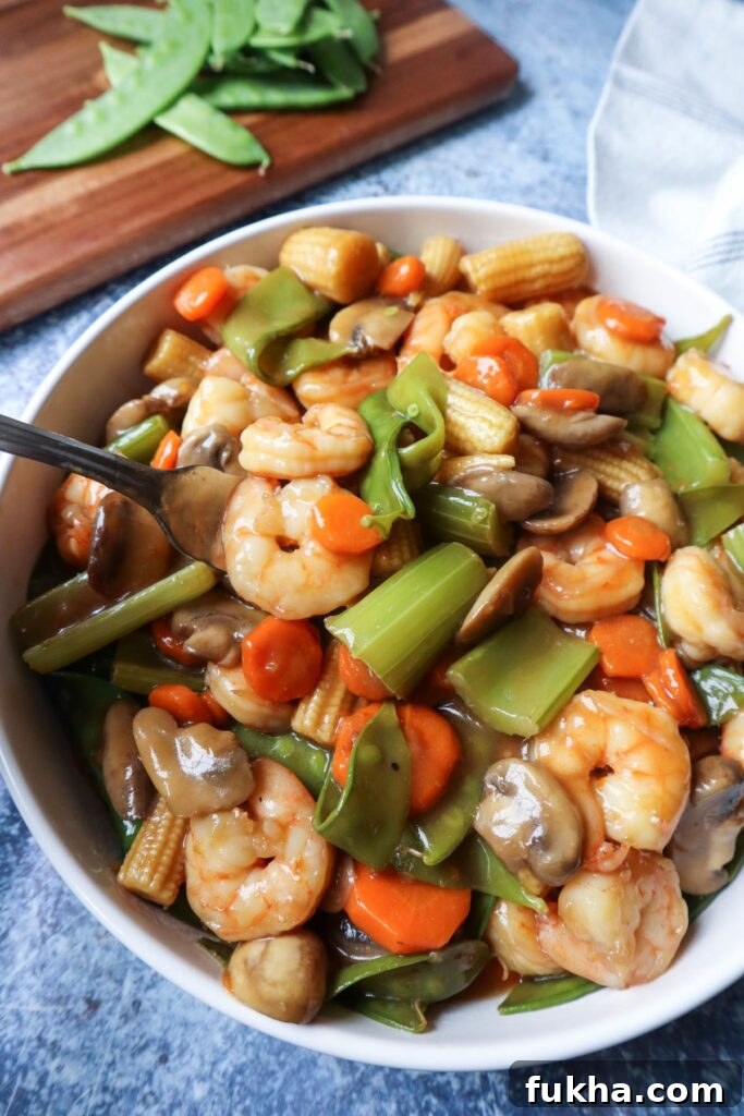 white bowl with shrimp chop suey with a fork
