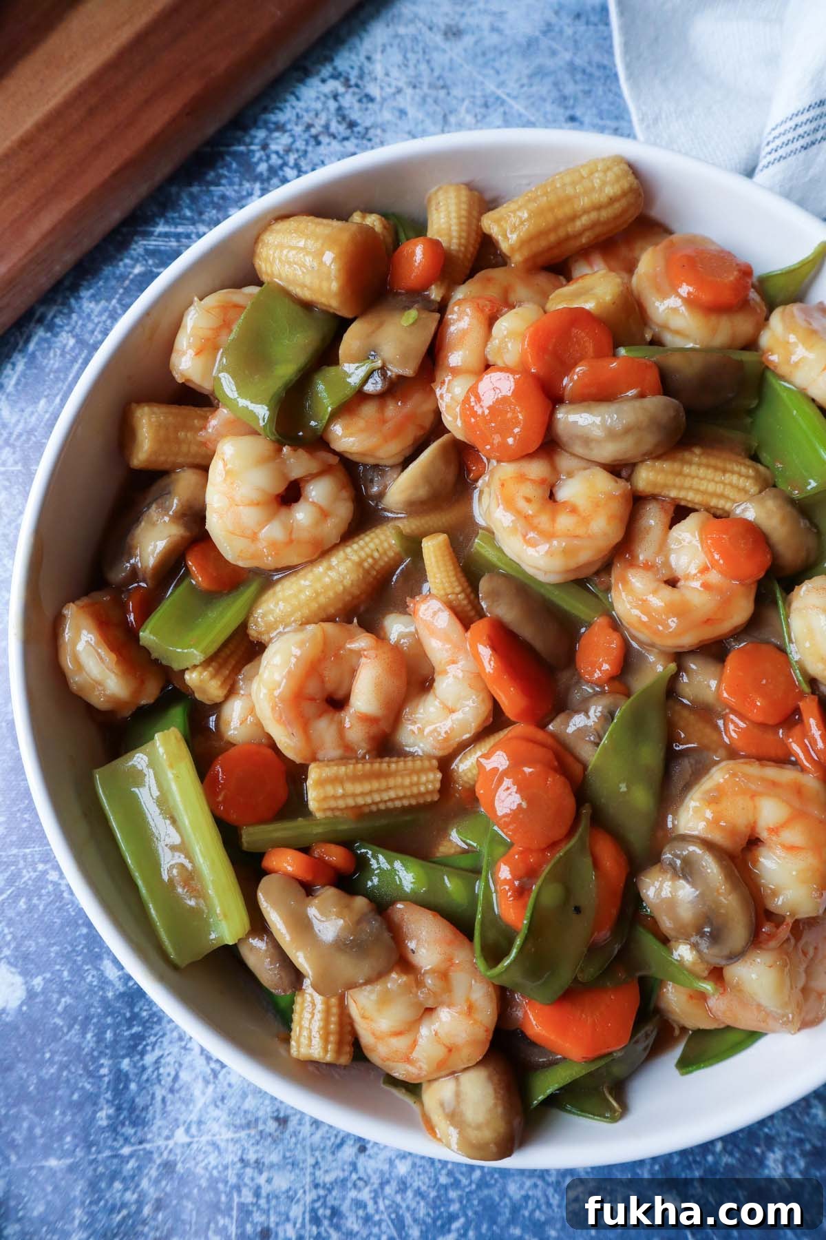 white bowl with shrimp chop suey with blue background