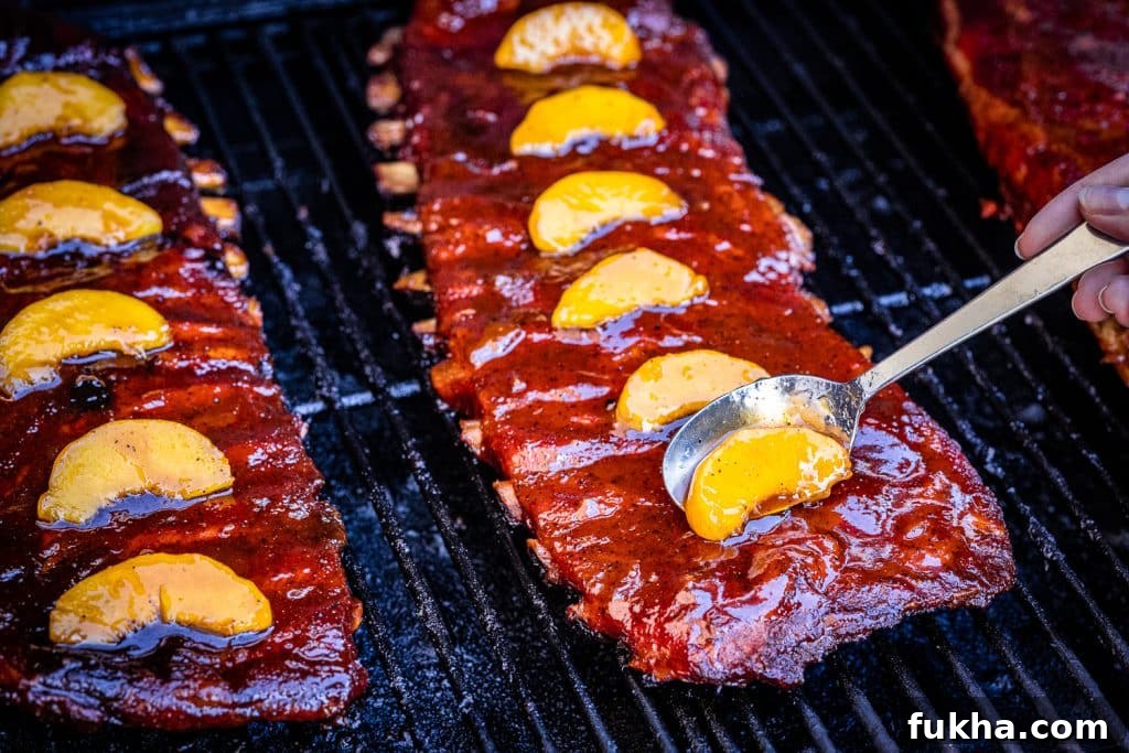 Peach slices being spooned onto fireball smoked ribs.
