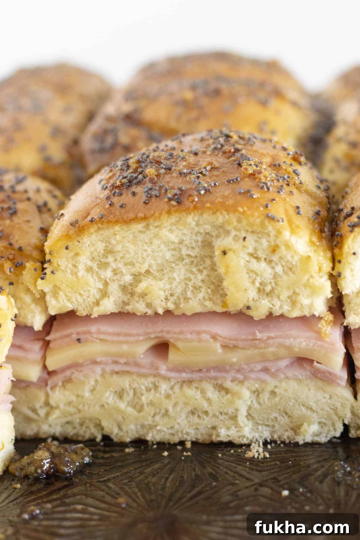 Brown Sugar Ham and Cheese Sliders Recipe with Sweet Glaze 2 Serving brown sugar and ham sliders on a tray.