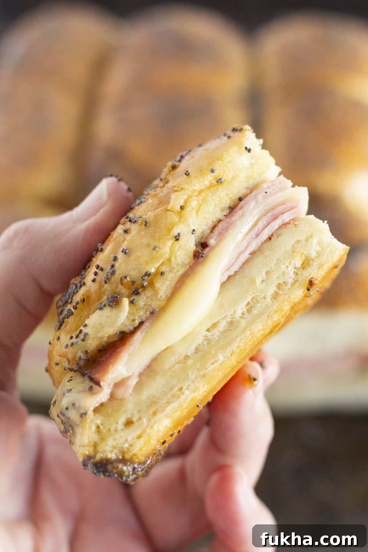 Brown Sugar Ham and Cheese Sliders Recipe with Sweet Glaze 6 Holding a brown sugar and ham slider.